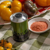Basil Extra Virgin Olive Oil next to a bowl of sea salt and tomatoes