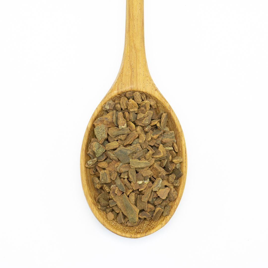 A wooden spoonful of ground cinnamon chunks.