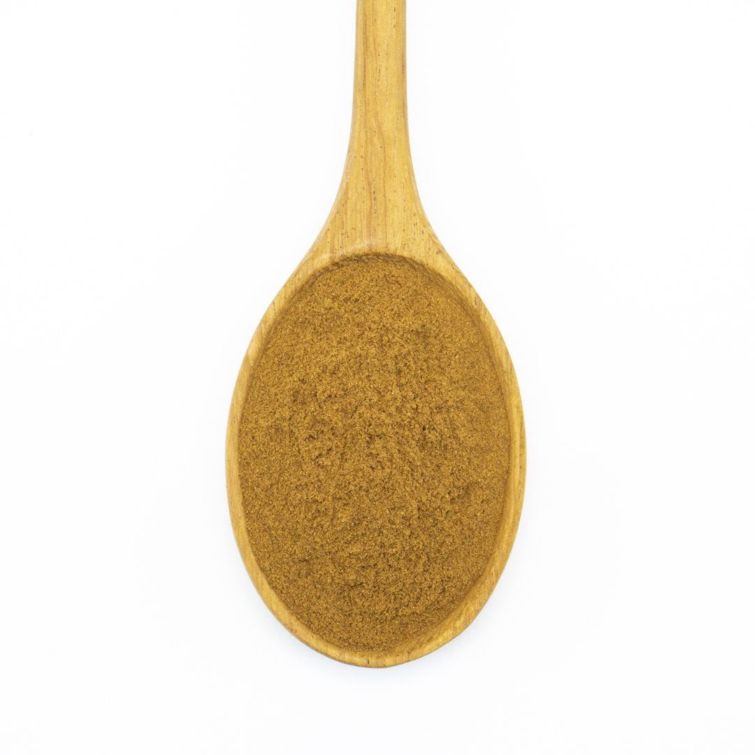 A spoonful of ground cinnamon spice, isolated on a white background.