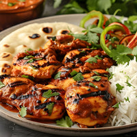 Tandoori chicken on place with pita and rice and vegetables